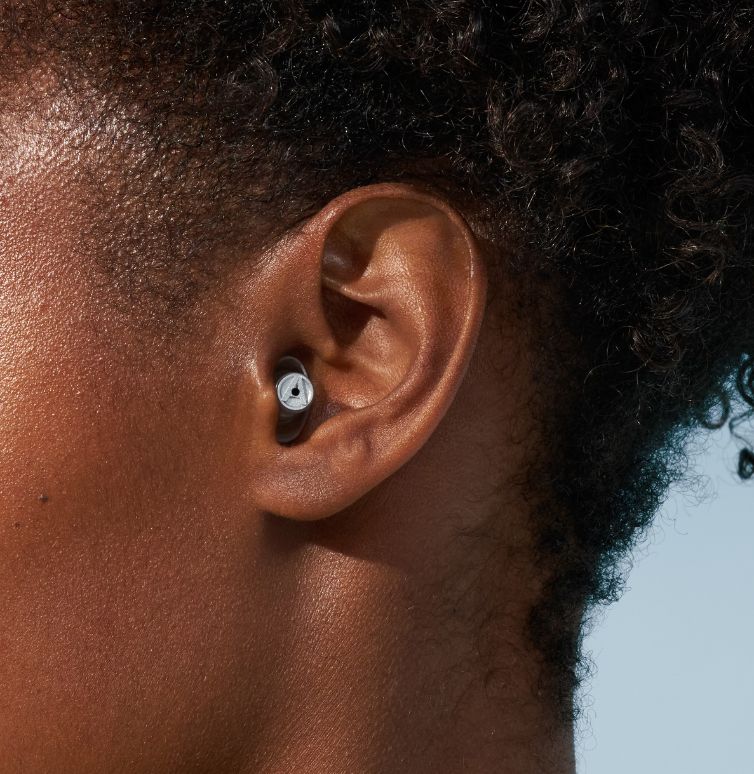 Nahaufnahme vom Ohr einer Frau mit Alpine-Ohrstöpseln.